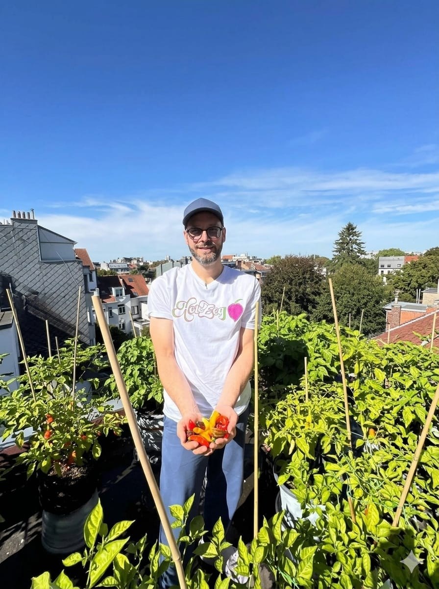 Le fondateur récolte des piments dans le jardin familial bruxellois.